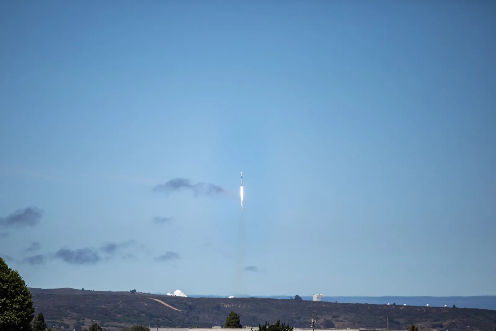 Foguete Falcon 9 subindo no céu azul a partir de Vandenberg, na Califórnia