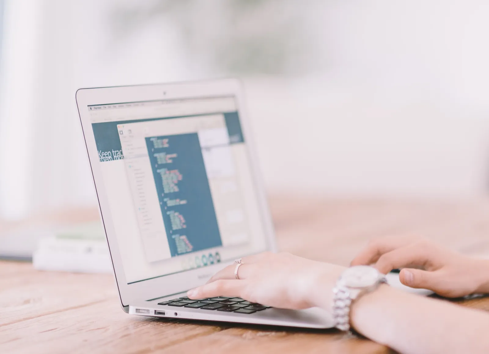 Pessoa digitando em um notebook, em ambiente de trabalho